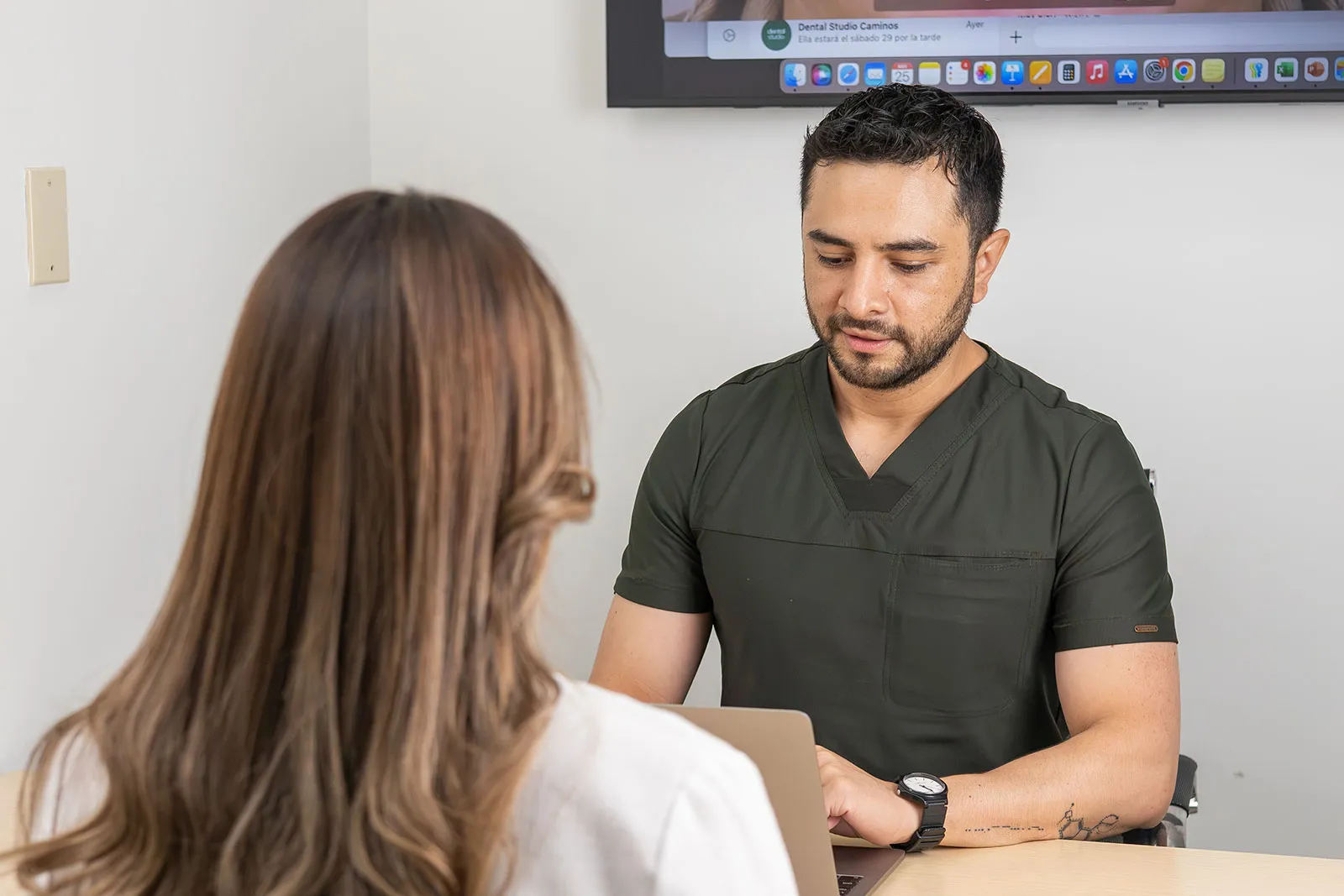 Doctor de Dental Studio explicando un tratamiento a una paciente
